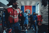 a man in a qatar shirt is dancing in a hallway