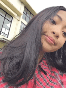 a girl in a red plaid shirt is taking a selfie