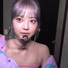 a close up of a woman wearing a necklace and a microphone on her neck .