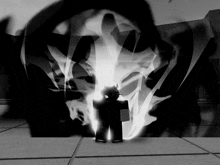 a black and white image of a person standing in front of a glowing object