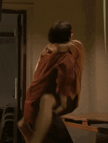 a man is carrying another man on his back in a room