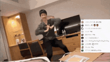 a man is dancing in front of a tv in a room with japanese writing