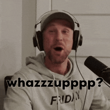 a man wearing headphones is talking into a microphone while wearing a hat that says friday on it .