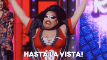 a drag queen says hasta la vista while raising her arms