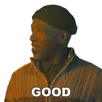 a man wearing a hat and sweater has the word good written on his face