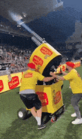 a man in a yellow shirt is pushing a box that says happy birthday