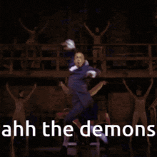 a man in a suit is dancing on a stage with a sword in his hand .