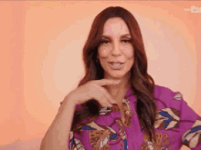a woman wearing a purple shirt is making a funny face