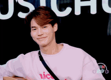 a young man wearing a pink shirt that says nice on it