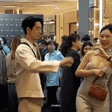 a man and a woman are standing next to each other in a crowded area .