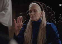 a woman with long blonde hair is wearing a headband and earrings