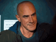 a bald man is smiling in front of a sign that says mon-tue 8 am
