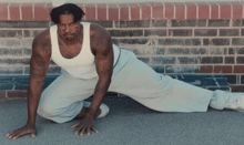a man is kneeling down in front of a brick wall and his pants say new england