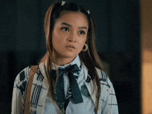 a girl in a school uniform has a badge that says university on it