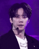 a close up of a man wearing a microphone and a shirt that says antoine on it