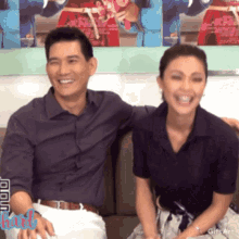 a man and a woman are sitting next to each other and laughing with a gif that says " hart " on the bottom