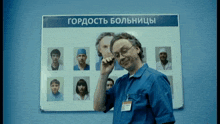 a man talking on a cell phone in front of a board that says " гордость больнице "