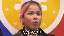 a woman is saying wow in front of a colorful background