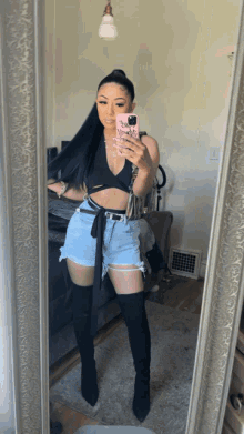 a woman taking a selfie in front of a mirror with a case that says chanel