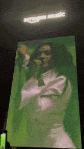 a woman singing in front of an amazon music banner