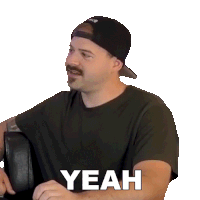 a man with a mustache is wearing a black shirt and a baseball cap and says yeah