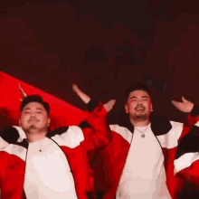 a group of men wearing red and white jackets are dancing together