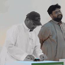 a man wearing an xbox hat is pressing a button