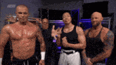 a group of men are standing in front of a aew logo