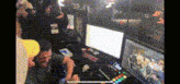 a group of people are playing a video game in a room with a lot of monitors .