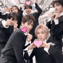a group of young men are posing with pink hearts on their heads