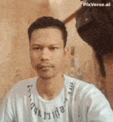 a man with a beard is taking a selfie with a white shirt that says pixverse.ai on it .
