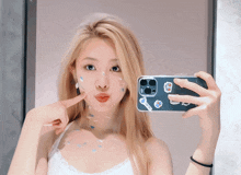 a woman is taking a picture of herself in a mirror with a sticker on her phone that says ' a '
