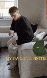a man is sitting on a couch with a cup of coffee and the words my favorite protei above him