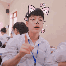a boy in a white shirt with a blue lanyard around his neck has a cat face on his face