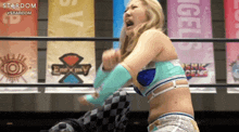 a woman in a wrestling ring with a banner that says stardom in the background