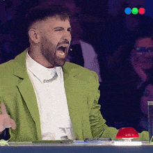 a man in a green jacket and white shirt is screaming