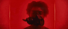 a close up of a person 's face with glowing eyes and a red background .