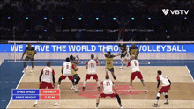 a volleyball game is being played in front of a sign that says we serve the world thro volleyball