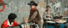 a man in a cowboy hat says piss off while playing drums