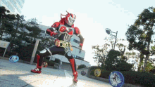 a man in a red and black costume is standing on a sidewalk surrounded by coins