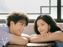 a man and a woman are sitting next to each other and the woman 's arm rests on the man 's lap