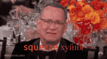 a man in a tuxedo and glasses says squeeze in red letters