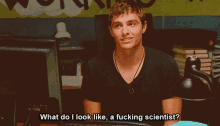 a man sitting in front of a computer with the words " what do i look like a fucking scientist " above him