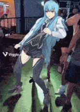 a girl with blue hair is dancing in front of a crowd with a viggle logo in the corner