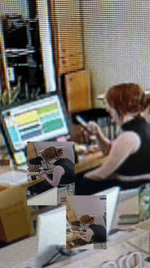 a woman sits at a desk looking at her phone