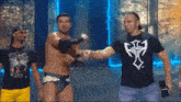 a man wearing a black shirt with a cross on it shakes hands with another man