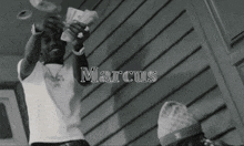 a black and white photo of a man holding money with the name marcus above him