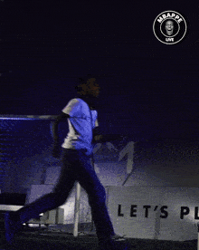 a boy is running in front of a sign that says play