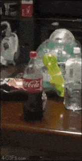 a bottle of coca cola is on a table next to a bag of chips .