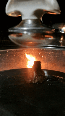 a close up of a glass container with a fire coming out of it